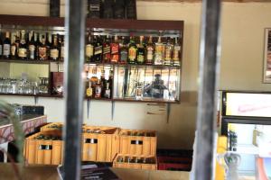 a bar with many bottles of alcohol on the wall at The Roots classic hotel in Njeru