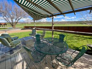 a patio with a table and chairs on a porch at Elderberry Farmhouse at Zenzen Gardens in Paonia
