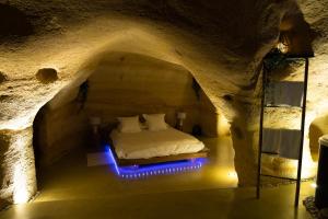 ein Schlafzimmer in einer Höhle mit einem Bett darin in der Unterkunft La falaise perdue : Suite troglodyte grandiose in Doué-la-Fontaine