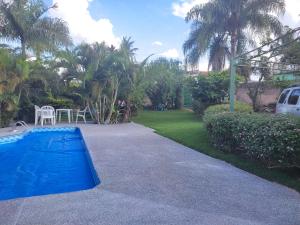 a blue swimming pool in a yard with a table and chairs at Hostel Casa do Sossego in Brasília