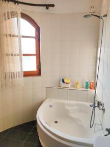 a white bathroom with a tub and a window at Casa Martina in Alexandroupoli