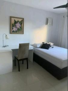 1 dormitorio con cama, escritorio y silla en Casa em Cabo Frio com piscina privativa, até 10 pessoas, en Cabo Frío