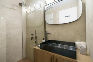 un baño con lavabo y espejo en Alkionides Hydra, en Hydra