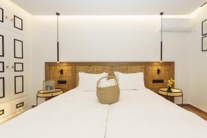 1 dormitorio con 1 cama blanca grande y 2 mesas en Alkionides Hydra, en Hydra