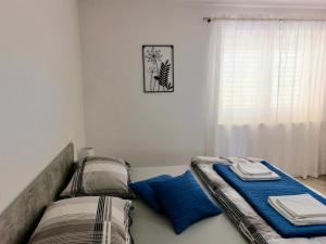 een slaapkamer met 2 bedden en een raam bij Apartment "None" Makarska in Makarska