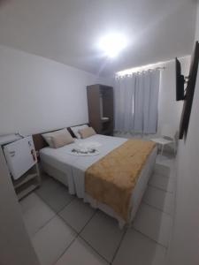a bedroom with a large white bed with a tan blanket at Jampa Mar Pousada in João Pessoa