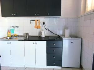 cocina con armarios blancos y nevera blanca en Apartment "None" Makarska en Makarska