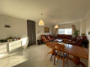 sala de estar con mesa de madera y sillas en Mahfouz Suite - Ajloun's downtown, en Ajloun