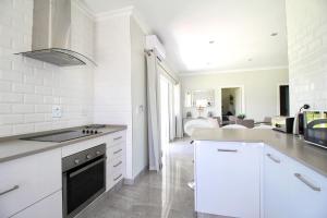 a kitchen with white appliances and a living room at Caribbean 1136 by Top Destinations Rentals in Port Edward