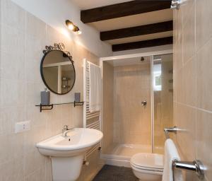 a bathroom with a sink and a toilet and a mirror at B&B Casa del Lago in Baveno