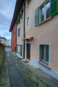 an empty street next to a building with green shutters at B&B Casa del Lago in Baveno