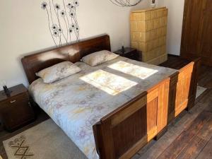 1 dormitorio con 1 cama grande con marco de madera en doLodge homestead in the Kolpa River canyon, en Stari Trg ob Kolpi