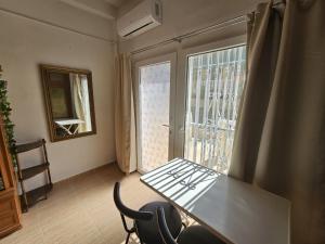 mesa y sillas en una habitación con ventana en Benidorm Bungalow la Siesta A26 en Benidorm