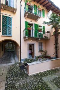 バヴェーノにあるB&B Casa del Lagoの緑のシャッターと中庭のあるアパートメントビル