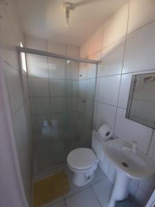 a white bathroom with a toilet and a sink at Jampa Mar Pousada in João Pessoa
