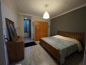 1 dormitorio con 1 cama grande y vestidor de madera en Mahfouz Suite - Ajloun's downtown, en Ajloun