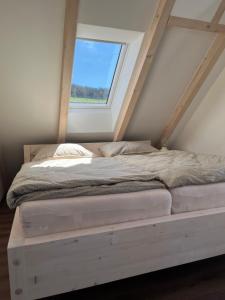 Cama en habitación con ventana en U Králíka, mezonetový apartmán H - 3 samostatné ložnice en Dolní Morava