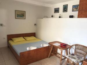 ein Schlafzimmer mit einem Bett, einem Tisch und einem Stuhl in der Unterkunft Zo-Mi Apartments in Tivat