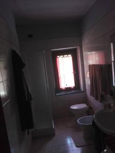 La salle de bains est pourvue de toilettes et d'une fenêtre. dans l'établissement Appartamento in cascina lombarda, à Caselle Lurani