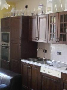 - une cuisine avec des placards en bois et un évier dans l'établissement Appartamento in cascina lombarda, à Caselle Lurani