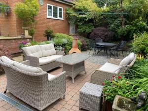 een patio met rieten meubels en een tafel en stoelen bij Grove House Bed & Breakfast in York