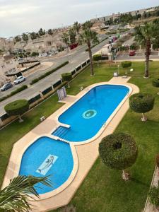 een uitzicht over een zwembad in een park bij Villamartin - Las Violetas 555 in Alicante