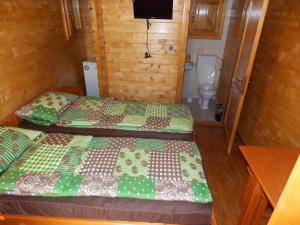 two beds in a small room with a toilet at Căsuțe Suzanne Băile Figa-cu aer conditionat in Beclean +8 photos