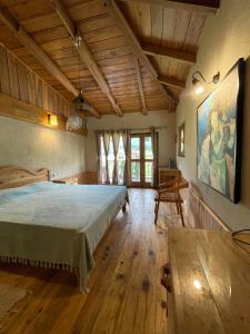 Osho Himalayas Wellness Resort في كانجرا: غرفة نوم بسرير كبير وارضية خشبية