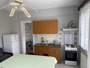 a small kitchen with a table and a ceiling fan at Welcome in Salamina in Salamís