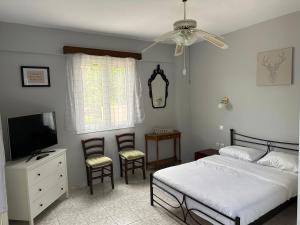 a bedroom with a bed and a tv and chairs at Welcome in Salamina in Salamís