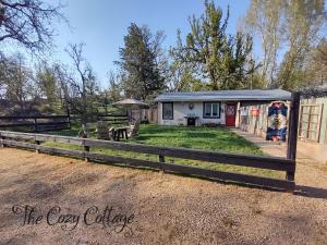 a house with a fence in front of it at Cozy Cottage in Miramonte