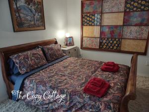 a bedroom with a bed with two red pillows on it at Cozy Cottage in Miramonte