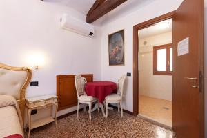 1 dormitorio con mesa, 2 sillas y 1 cama en Alloggi SS Giovanni e Paolo, en Venecia