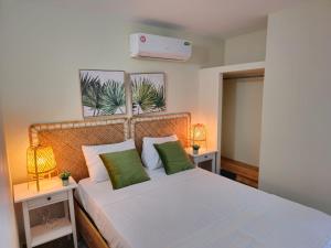 une chambre avec un lit avec deux tables de nuit et deux lampes dans l'établissement Residence Parque, à Saint-Domingue
