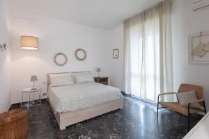 1 dormitorio blanco con 1 cama y 1 silla en Marte 87 en Florence