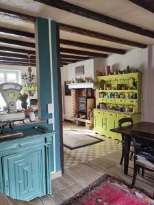 a living room with a table and yellow cabinets at chambres d hotes L'agapé in Saint-Martial-sur-Isop