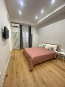 ein Schlafzimmer mit einem großen Bett und Holzboden in der Unterkunft La Piccola Formica Home in Palermo