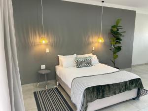 a bedroom with a bed and a table and lights at 10 Paul Roos in Kimberley