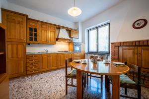 a large kitchen with a wooden table and chairs at Lake view apartment with balcony and parking - Larihome A25 in Gera Lario
