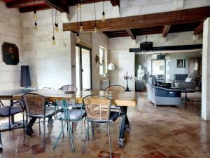 a dining room with a table and chairs and a couch at Le Bastion des Papes in Châteauneuf-de-Gadagne