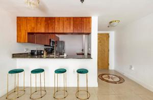 a kitchen with four green stools in front of a counter at Two Bedroom Oceanview Apartment in Brickell in Miami