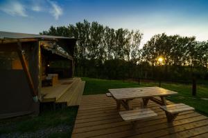 una terraza de madera con mesa de picnic y cenador en Le Relais d'Artagnan - relais équestre, en Mortier