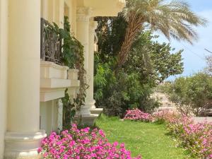 uma casa com flores cor-de-rosa ao lado dela em Bahga Palace 5 Residential Apartments em Hurghada