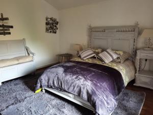 a bedroom with a large bed and a rug at chambres d hotes L'agapé in Saint-Martial-sur-Isop