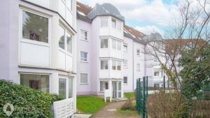 un edificio de apartamentos blanco con una valla verde en Business-Apartment, en Amberg