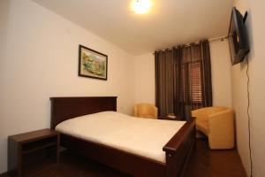 a small bedroom with a bed and a television at Apartment Biba in Virpazar