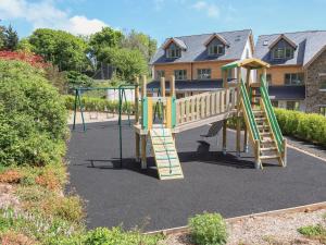 a playground with a slide in front of a house at 4 Court Terrace, Hillfield Village in Dartmouth
