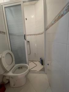 a bathroom with a toilet and a shower in it at Cap Juby Apartment 1 in Tarfaya +1 photo