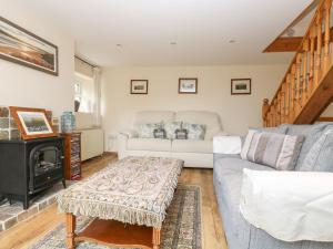 a living room with a couch and a fireplace at Curlews in Tintagel