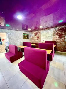 a restaurant with purple chairs and a table and a table and chairs at Sweet Home in Dnipro